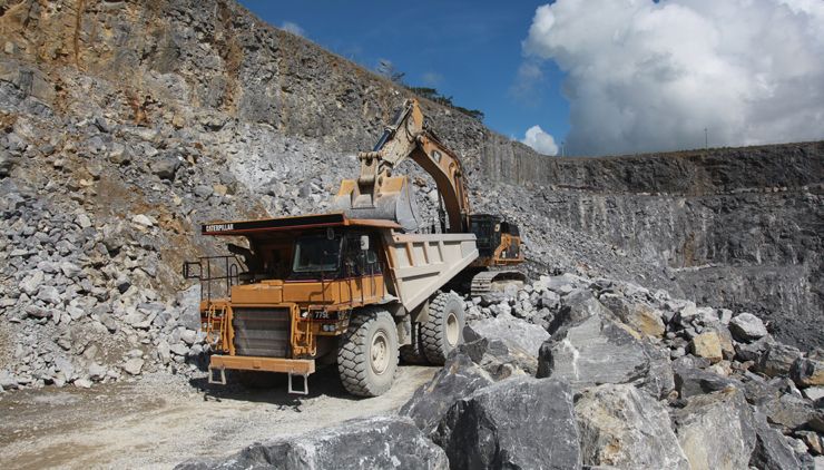 Digger loading rock armour for riverbank protection